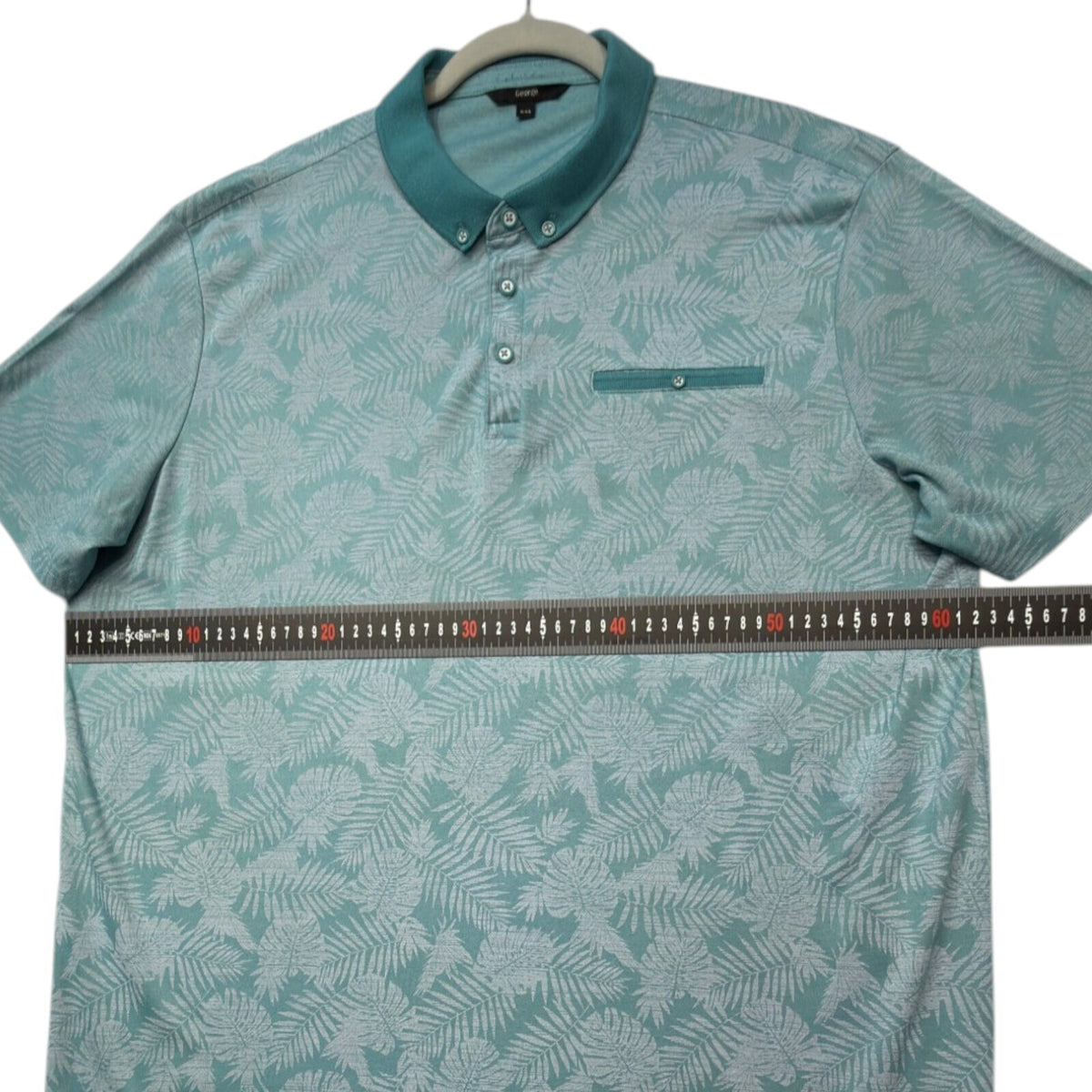 George green polo shirt with pocket, button-down, nature-inspired pattern.