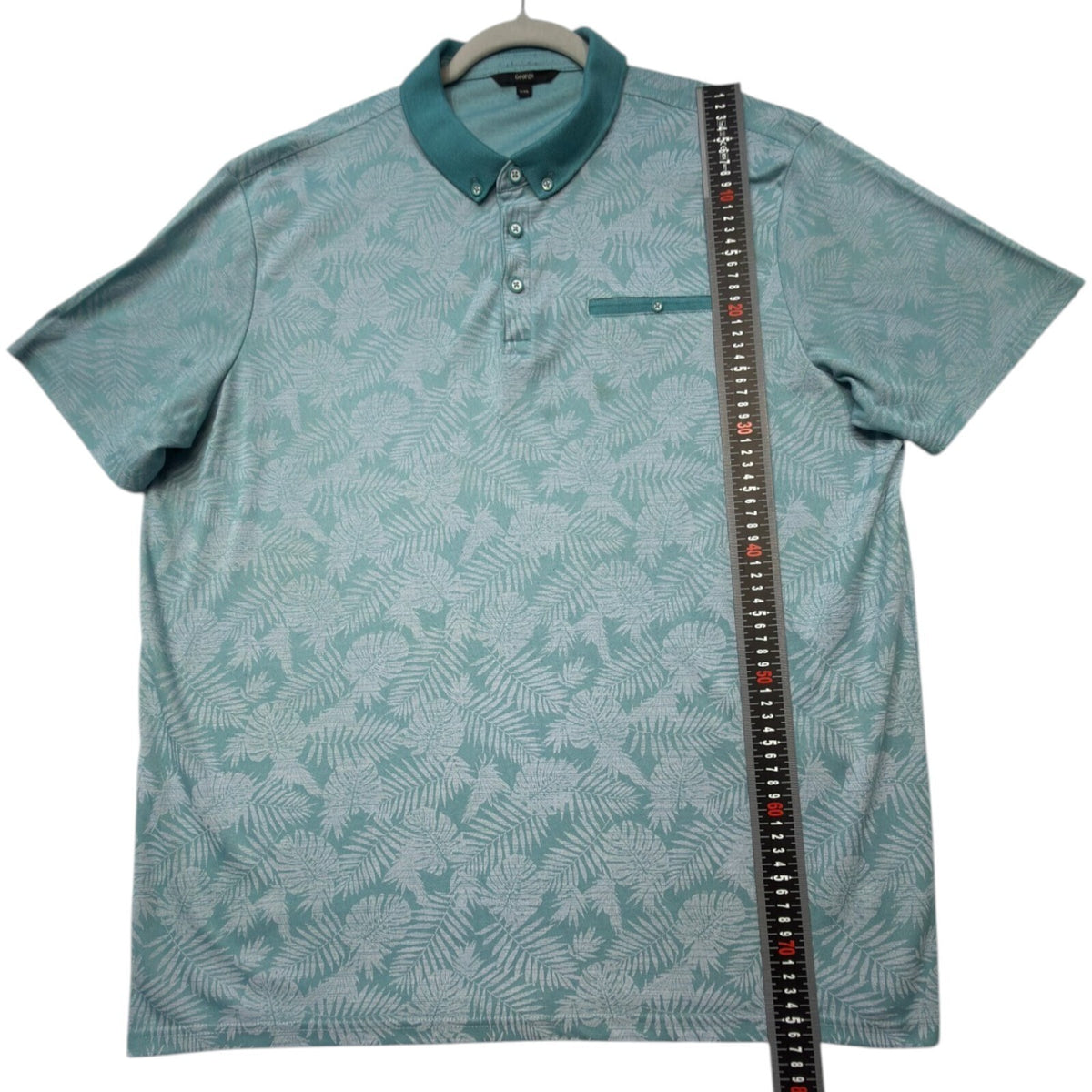 George green polo shirt with pocket, button-down, nature-inspired pattern.